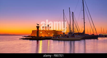 Mandraki harbour and fortress Agios Nicolaos before sunrise, Rhodes town, Rhodes Island, Greece, UNESCO Stock Photo