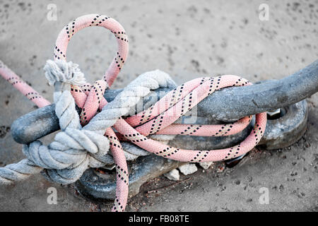 Nautical ropes tied around horn cleat on dock, close up.  Key West harbor, Florida. Stock Photo