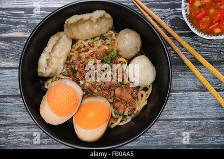 Mie Medan, Chinese style noodle soup from Medan. Served with diced pork, duck egg, dumplings and fish balls. Stock Photo