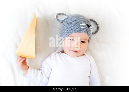 Baby boy in mouse hat lying on blanket with cheese Stock Photo