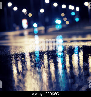 Abstract dark blurry urban background. Wet road. Stock Photo
