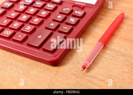 Modern Red Calculator And Pen on Table Stock Photo