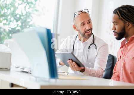 Doctor giving consultation to patient using digital tablet Stock Photo