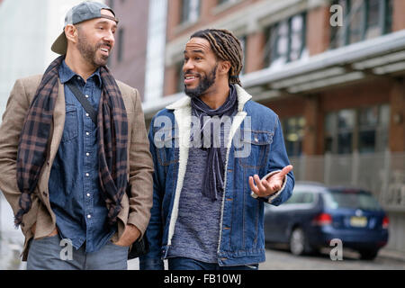 Smiley homosexual couple walking down street Stock Photo