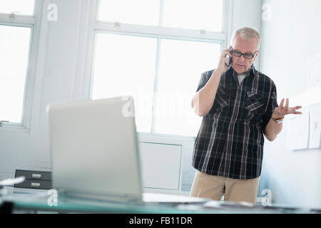 Man in office using smartphone Stock Photo