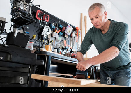 Man working with wood in home workshop Stock Photo