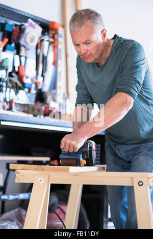 Man working with wood in home workshop Stock Photo