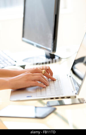 Hands typing on laptop keyboard Stock Photo