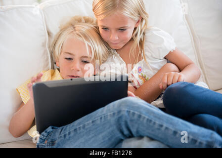 Girl (6-7) and boy (4-5) looking at digital tablet