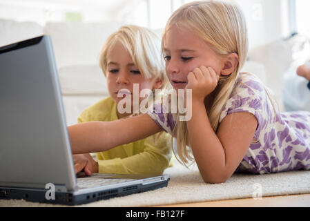 Boy (4-5) and girl (6-7) using laptop Stock Photo