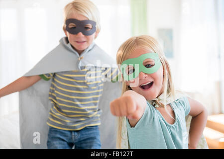 Boy (4-5) and girl (6-7) wearing masks Stock Photo