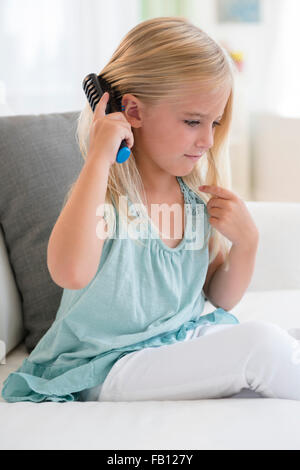 Girl (6-7) brushing hair Stock Photo