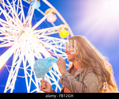 Woman holding cotton candy at funfair Stock Photo