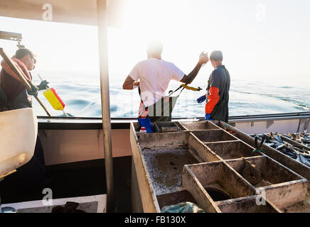 Fishermen working on boat Stock Photo