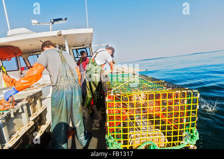 Three fishermen working on boat Stock Photo