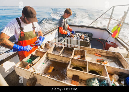 Two fishermen working on boat Stock Photo