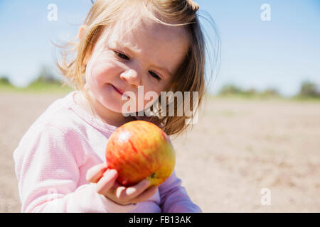 Portrait of girl (2-3) holding apple Stock Photo
