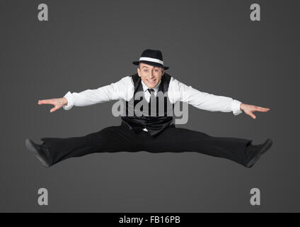 Young male professional dancer dancing in studio isolated on gray background. Stock Photo