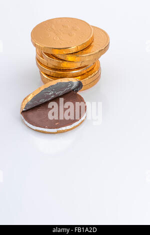 Stack of chocolate money covered in fake gold foil. Supposed to be UK 2p/two pence coins. Stock Photo