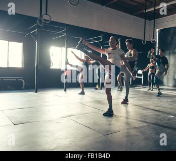 Men and women exercising together in gym