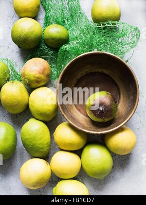 Overhead view of lemons in bowl and net packaging Stock Photo