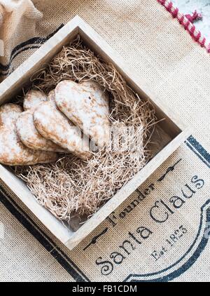 Overhead view of heart shaped gingerbread cookies on Christmas printed burlap sack Stock Photo