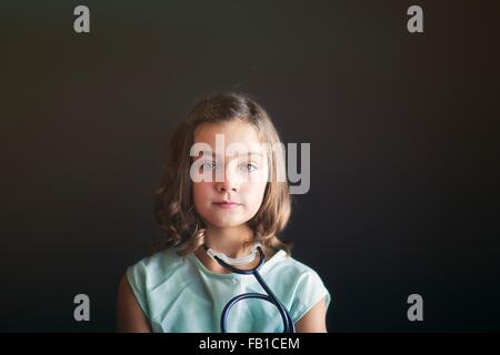 Portrait of girl dressed up as nurse wearing stethoscope looking at camera Stock Photo
