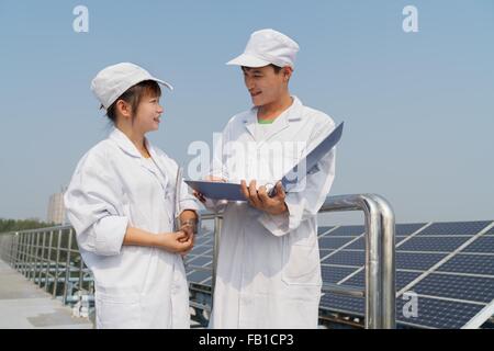Workers on roof of solar panel assembly factory, Solar Valley, Dezhou, China Stock Photo