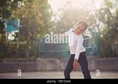 Elementary schoolboy dancing in playground Stock Photo