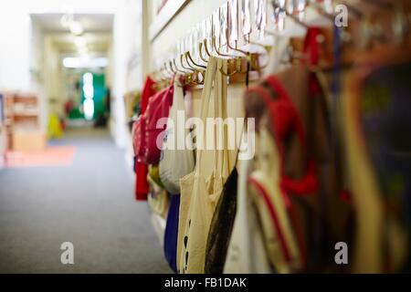 School bags hanging on row of coat hooks in elementary school Stock Photo