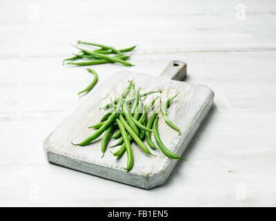 Extra fine green bean on wooden chopping board Stock Photo
