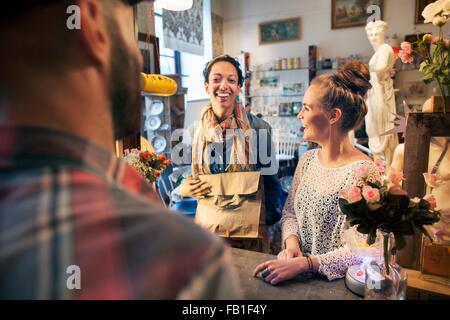 Two happy young female customers buying from vintage shop