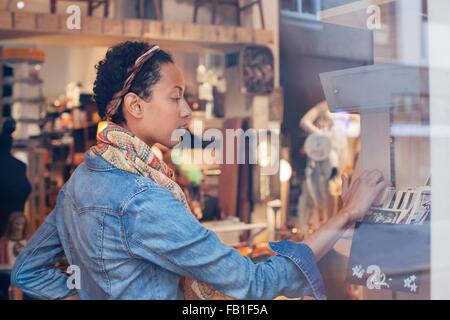 Young woman searching old photographs in vintage shop Stock Photo