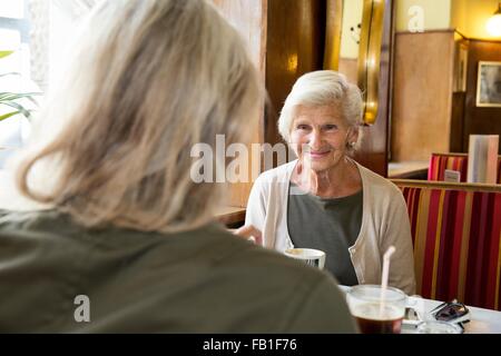 Mother and daughter sitting together in cafe Stock Photo