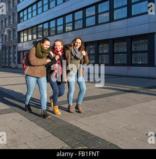 female high school students girls women females walk walking street Stock Photo