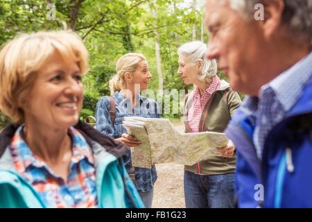 Group of friends on hiking trail, looking at map