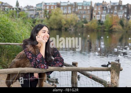 Young woman relaxing by lake, Hampstead Heath, London Stock Photo