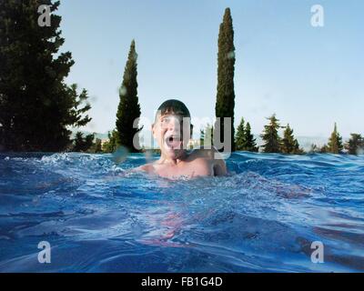 Fun portrait of teenage boy in outdoor swimming pool Stock Photo