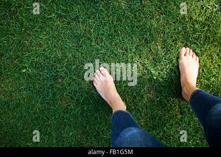 Woman standing on grass, low section, elevated view Stock Photo