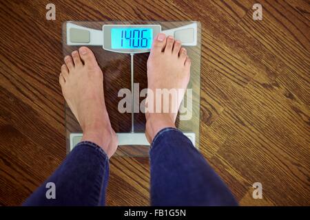 Woman standing scales with digital display, low section, elevated view Stock Photo
