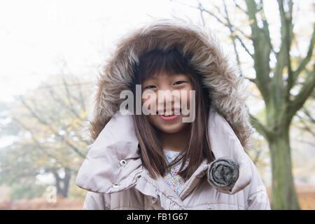 Portrait of young girl wearing winter coat, smiling Stock Photo