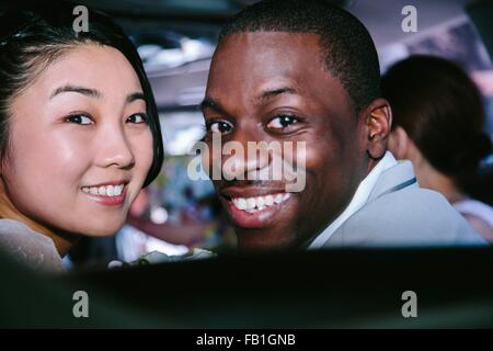 Portrait of couple looking over shoulder at camera smiling Stock Photo