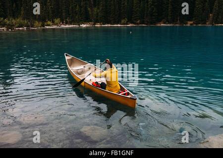 High angle rear view of mid adult man paddling canoe on Moraine lake, Banff National Park, Alberta Canada Stock Photo
