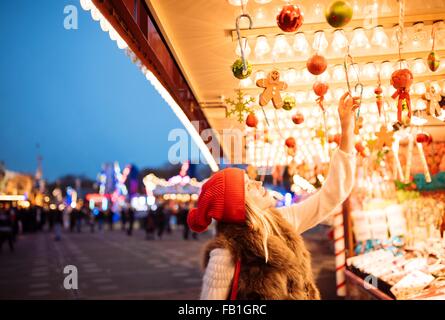 Young woman choosing baubles at xmas festival in Hyde Park, London, UK Stock Photo