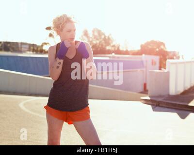 Young female boxer training in parking lot Stock Photo