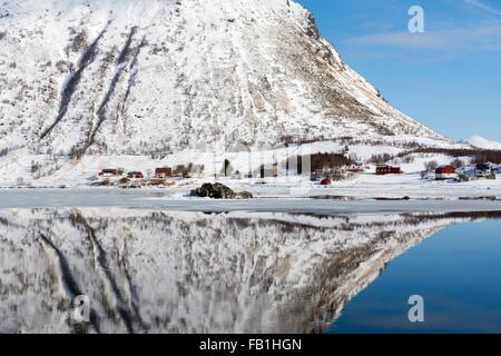 Snow covered mountain reflected in water, Knutstad, Lofoten Islands, Norway Stock Photo
