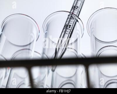 Low angle view of graduated pipette pipetting liquid into test tube Stock Photo