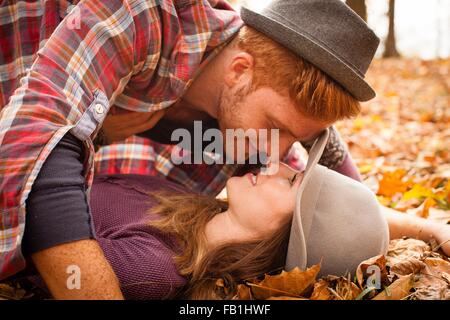 Young couple face to face on autumn forest floor Stock Photo