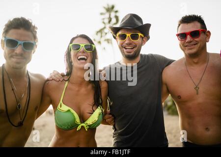 Portrait of young woman and three young men on beach, Newport Beach, California, USA Stock Photo