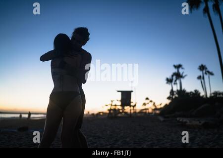 Romantic young couple hugging at sunset, Newport Beach, California, USA Stock Photo